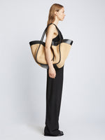 Image of model carrying XL Raffia Ruched Tote in BLACK/SAND on shoulder