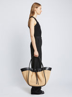 Image of model carrying XL Raffia Ruched Tote in BLACK/SAND in hand