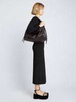Image of model carrying Large Drawstring Shoulder Bag in BLACK on shoulder