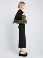 Image of model carrying Large Drawstring Shoulder Bag in OLIVE on shoulder