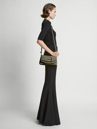 Image of model carrying Small Bar Bag in OLIVE on shoulder