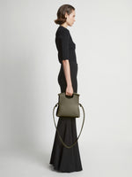 Image of model carrying Small Bar Bag in OLIVE in hand