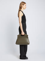 Image of model carrying Bar Bag in OLIVE with handles up