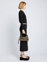 Image of model carrying Mini Drawstring Bag in OLIVE