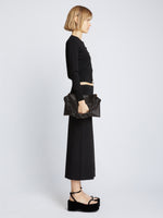 Image of model carrying Carved Python Braid Bag in BLACK in hand