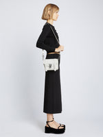 Image of model carrying Carved Python PS1 Mini Crossbody Bag in OPTIC WHITE