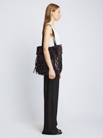 Image of model carrying Macrame Drawstring Tote in BLACK on shoulder