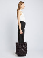 Image of model carrying Macrame Drawstring Tote in BLACK in hand