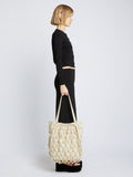 Image of model carrying Macrame Drawstring Tote in ECRU in hand