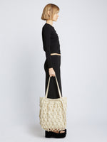 Image of model carrying Macrame Drawstring Tote in ECRU in hand