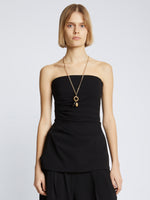 Cropped front image of model in Matte Viscose Crepe Strapless Top in Black