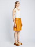 Side full length image of model wearing Glossy Leather Skirt in CARAMEL
