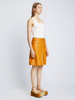 Side full length image of model wearing Glossy Leather Skirt in CARAMEL