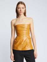 Front cropped image of model wearing Glossy Leather Strapless Top in CARAMEL