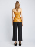 Back full length image of model wearing Glossy Leather Strapless Top in CARAMEL