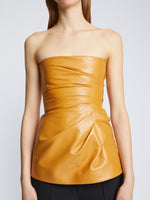 Detail image of model wearing Glossy Leather Strapless Top in CARAMEL