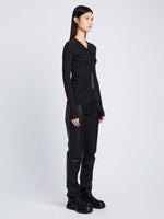 Side full length image of model wearing Matte Crepe Long Sleeve Top in BLACK