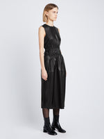 Side full length image of model wearing Faux Leather Drawstring Dress in BLACK