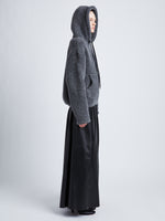 Side full length image of model wearing Technical Boucle Knit Hoodie in GREY