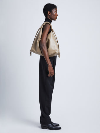 Image of model wearing Large Drawstring Shoulder Bag in MUSHROOM