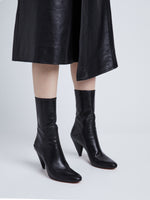 Image of model wearing CONE ANKLE BOOTS in BLACK