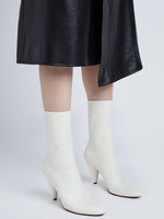 Image of model wearing CONE ANKLE BOOTS in CREAM