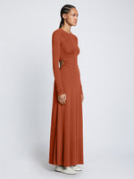 Side full length image of model wearing Long Sleeve Jersey Open Back Dress in RUST