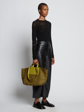 Image of model carrying Large Morris Raffia Tote in MOSS in hand