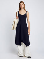 Front full length image of model wearing Barre Bustier Dress in NAVY styled over white Drapey Suiting Pants