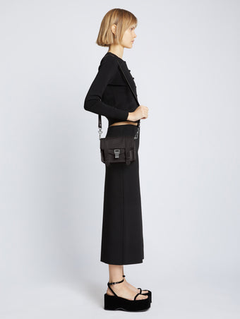 Image of model carrying Carved Python PS1 Mini Crossbody Bag in BLACK