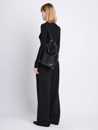 Image of model wearing  image of Spring Bag In Leather in black as sling