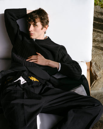 Male model sitting on white couch