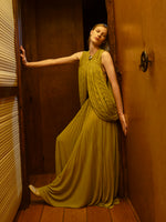 Image of model wearing Bari Dress in Gauzy Jersey in Olive in a room with wooden walls and floor