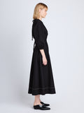 Side full length image of model wearing Nora Backless Dress in BLACK