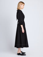Side full length image of model wearing Nora Backless Dress in BLACK