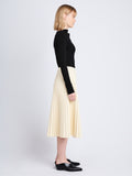 Side image of model wearing Daphne Skirt In Faux Leather in parchment