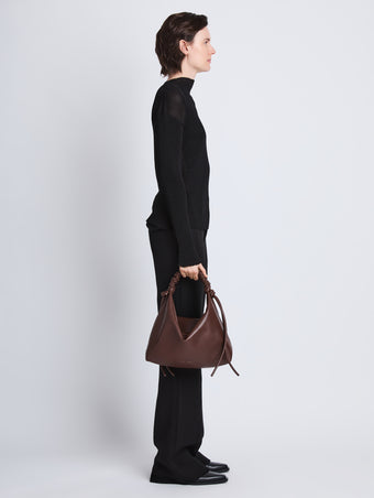 Image of model wearing Medium Drawstring Shoulder Bag in MOCHA