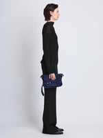 Image of model wearing Suede Beacon Saddle Bag in DEEP NAVY