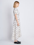Side full length image of model wearing Vivienne Asymmetrical Dress in WHITE MULTI
