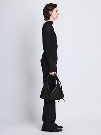 Image of model wearing Medium Drawstring Shoulder Bag in BLACK