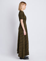 Side full length image of model wearing Vivienne Asymmetrical Dress in OLIVE MULTI