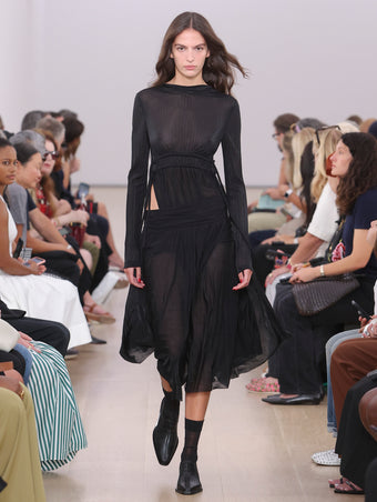 Model Walking Proenza Schouler SS24 Runway In Riley Dress In Black Pleated Jersey, Bronco Oxfords In Black Perforated Calf