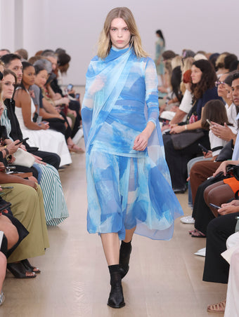 Model Walking Proenza Schouler SS24 Runway In Amber Top In Cerulean Printed Nylon Jersey, Judy Skirt In Cerulean Printed Nylon Jersey, Flip Shoulder Bag In Cyan Silk Satin, Bronco Oxfords In Black Perforated Calf