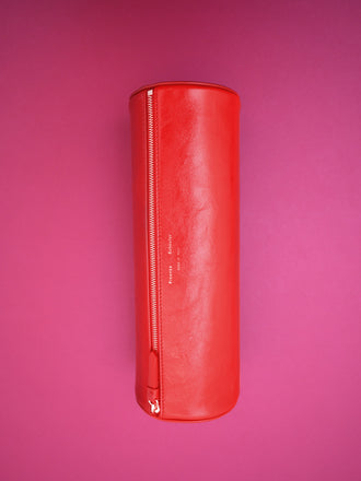 Editorial image of Silo Clutch in Shiny Calf in Red on pink background