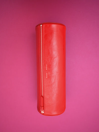 Editorial image of Silo Clutch in Shiny Calf in Red on pink background
