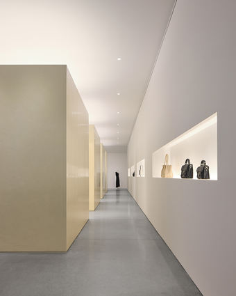 Interior image of new Proenza Schouler flagship store at 153 Mercer Street in New York. Large resin cubes filled with clothing and handbags dominate a white room with concrete floors.