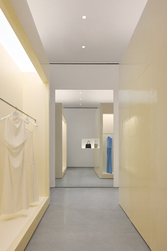Interior of new Proenza Schouler flagship store at 153 Mercer Street. Image of large resin cubes with railings installed, displaying a white and light blue dress