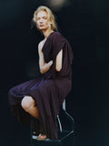 Proenza Schouler image of model sitting on a stool wearing Gabri Dress in Gauzy Pleated Jersey in Aubergine