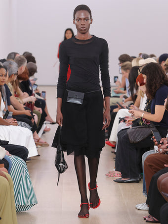 Model Walking Proenza Schouler SS24 Runway In Dara Top In Black Technical Nylon Jersey, Julia Skirt In Black Micro Pleat Jersey, Net Sling Bag In Black Tulle, Tee Toe Ring Sandals In Red Nappa