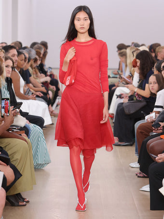 Model Walking Proenza Schouler SS24 Runway In Dara Top In Red Technical Nylon Jersey, Julia Skirt In Red Micro Pleat Jersey, Net Sling Bag In Red Tulle, Tee Thong Sandals In Birch Silk Satin